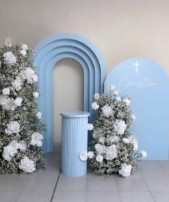 Light blue bliss baby package for baptism backdrop setup with floral columns and white baby’s breath arrangements.