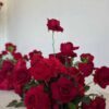 Red rose floral centerpiece with lush greenery for elegant event decor.