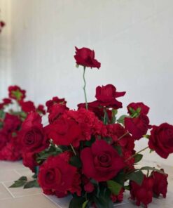 Red rose floral centerpiece with lush greenery for elegant event decor.