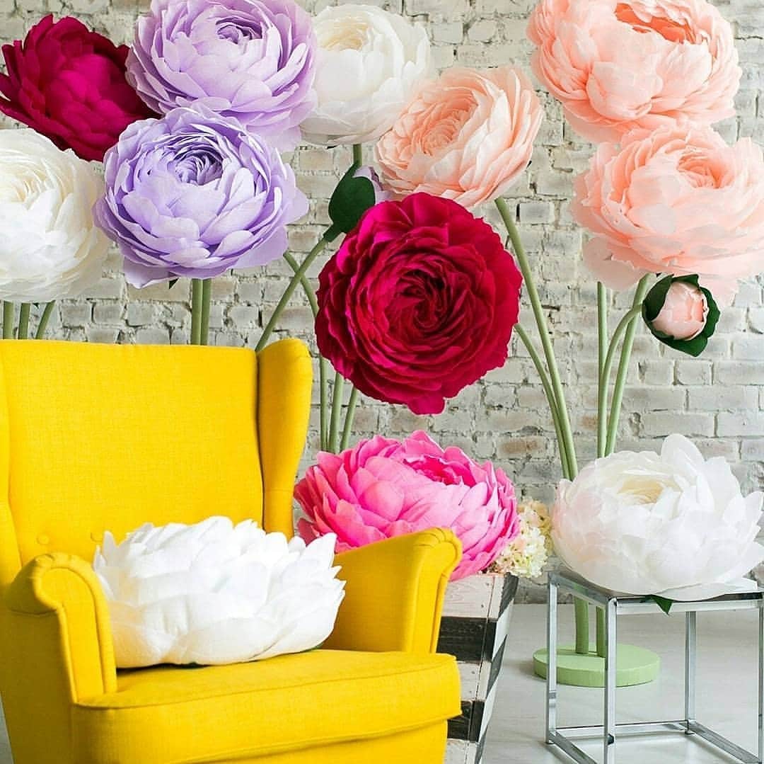 Oversized handmade flowers in vibrant colors with yellow chair setup by Magic Flowers Event Rentals decor rentals Woodbridge