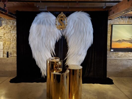 White angel wings backdrop with gold plinths for wedding and event rentals in Toronto and GTA