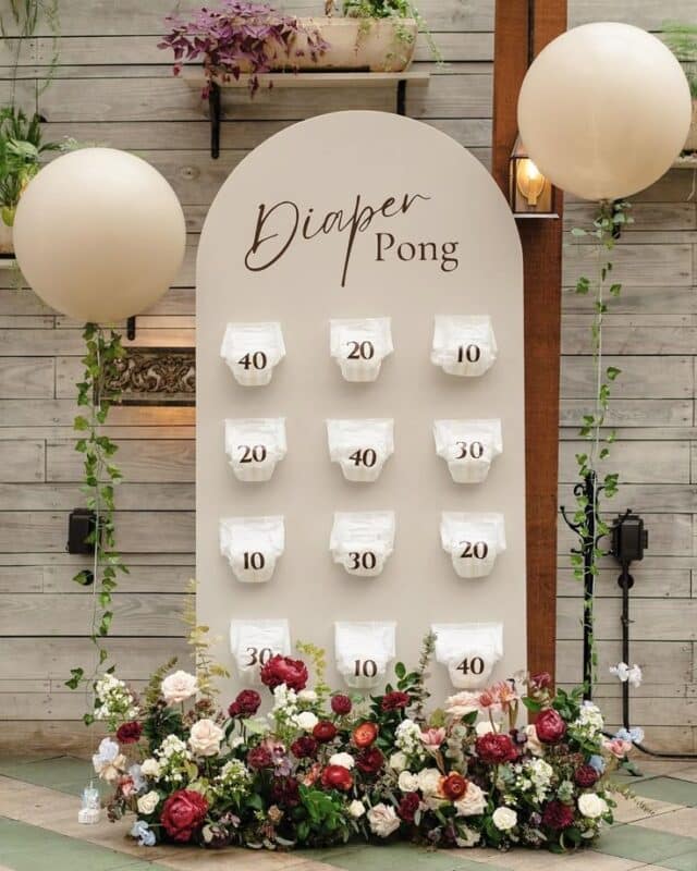 Diaper Pong Baby Shower game backdrop rental with floral arrangement.