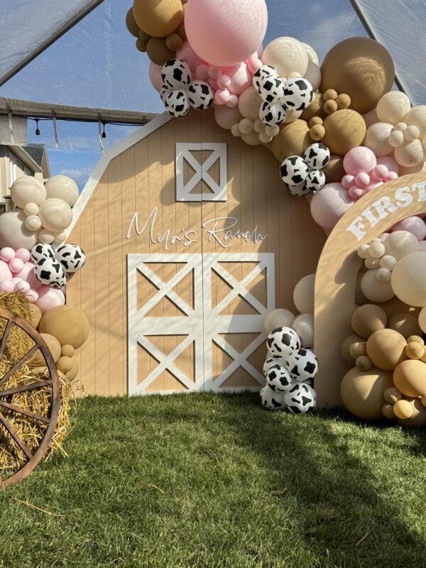 Farm-themed kids 1st birthday backdrop in Markham with barn house, cow-print balloons, and neutral pink balloon garland
