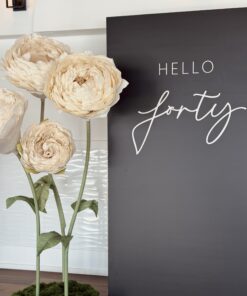 Ivory floral anniversary birthday display featuring oversized standing flowers and minimalist signage styled by Magic Flowers Event Rentals in Woodbridge, Vaughan
