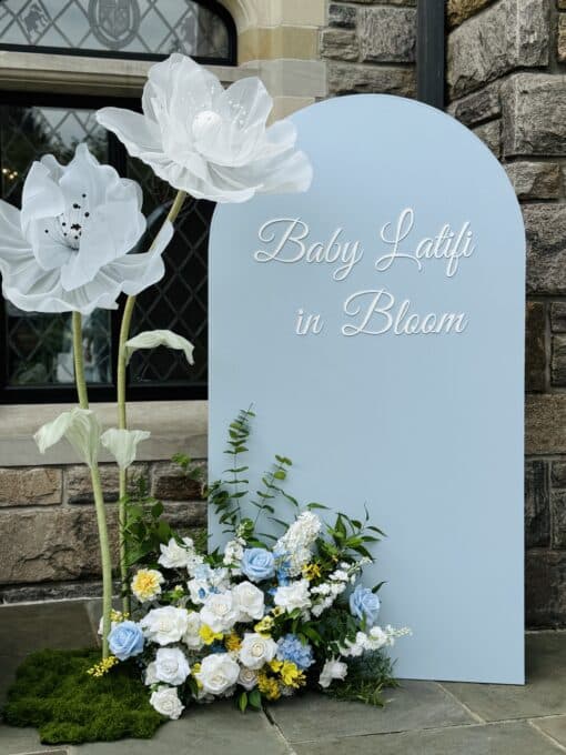 elegant blue backdrop with jumbo flowers and flower arrangement for a boy baby shower in Toronto