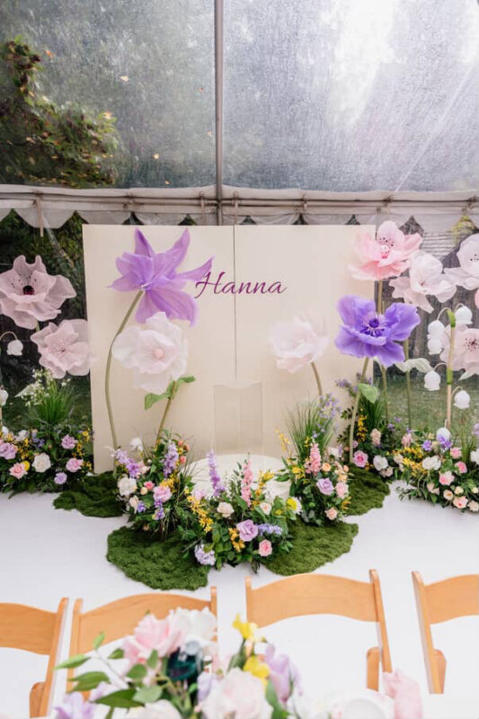 Custom ivory square backdrop rental featuring a hand-crafted garden of oversized magic flowers and lush forest moss for a kids' birthday party in Oakville.