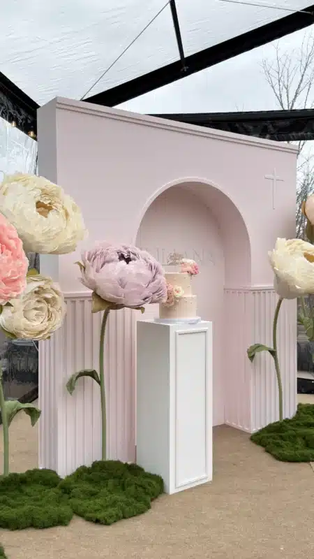 Oversized cream, blush, and lavender giant flowers decor framing a wedding cake setup in Aurora, Ontario.