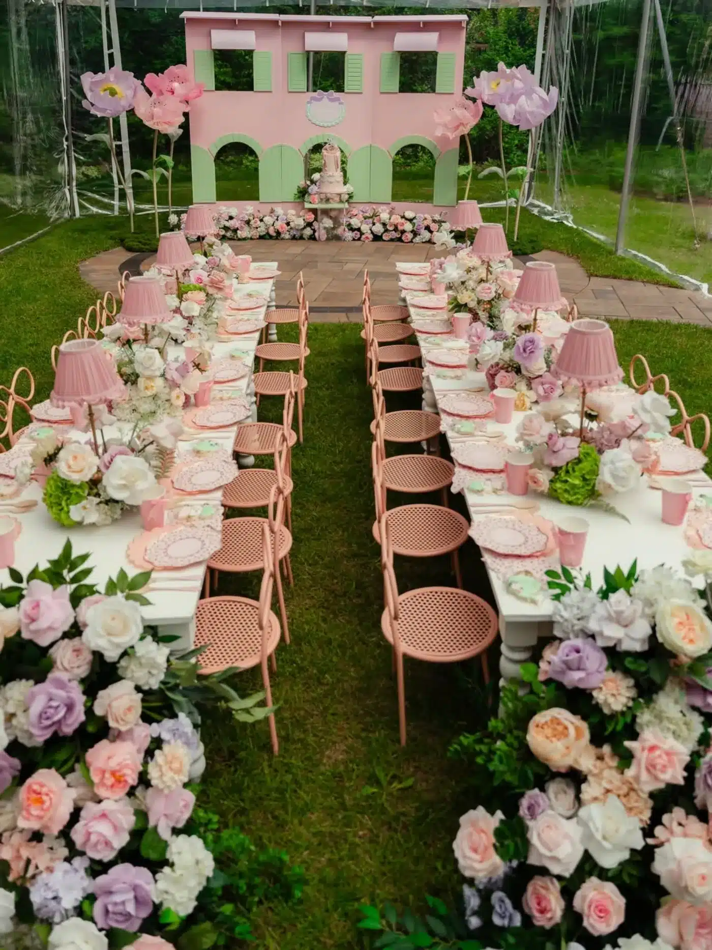 Kids' birthday party decor setup in Mississauga featuring pink bow chairs, wooden tables, and oversized floral centerpieces.