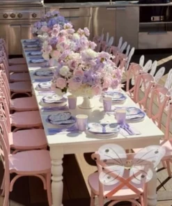 Fairy butterfly kids table setup with pink chairs, white butterfly wings, pastel floral centrepieces, and lavender place settings.