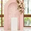Blush pink floral package with a soft floral-patterned centre panel, cascading pink and ivory flower arrangement, and white framed plinth for elegant events.