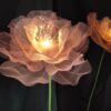 Giant Light-Up Flowers with warm glowing lights on a tall green stem for weddings and corporate event decor.