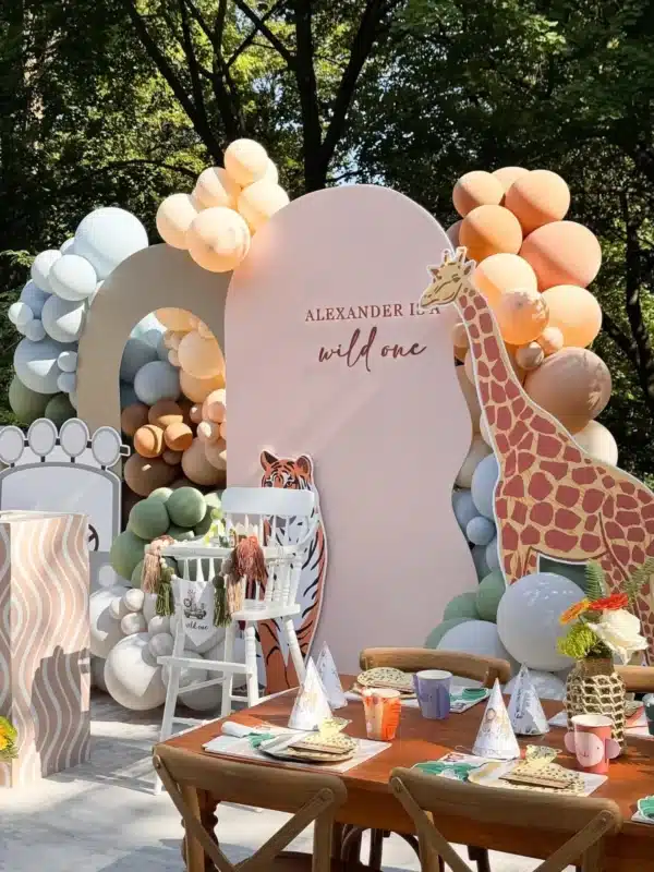 Safari theme 1st birthday decor setup in Brampton by Magic Flowers Event Rentals, featuring a pastel balloon garland, custom arch backdrop, and animal cutouts.