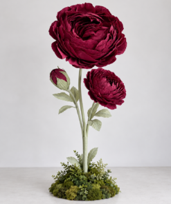 burgundy peony flower trio with two open blooms and one bud on tall green stems, finished with leaves and a lush moss-covered botanical base.