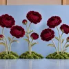 Giant burgundy peony flowers with coordinating buds, tall sculptural stems, and green moss-covered bases displayed in front of a light blue event backdrop.